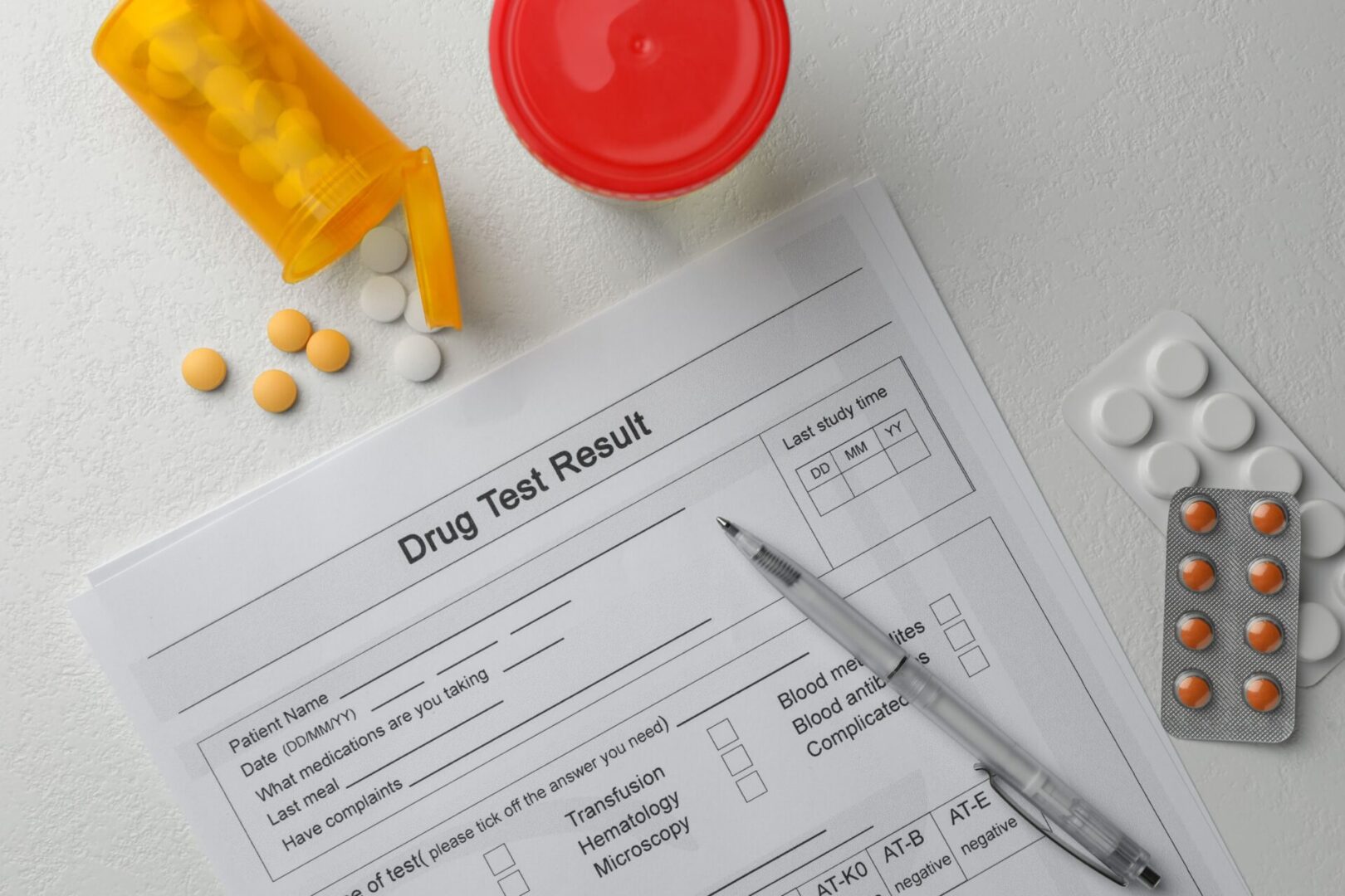 drug test result and medicine scattered across table desk